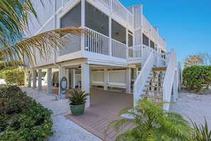 A multi-story building with a covered outdoor area, a staircase, and a vehicle charging station. - Gulf-Front Bliss | Soothing Waves, Breathtaking Sunsets & the Peaceful Charm of Boca Grande (Boca Grande)