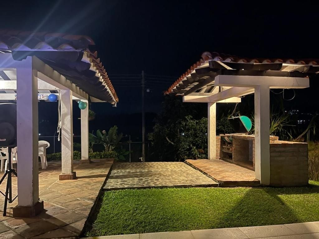 Un espace extérieur aménagé en terrasse, doté d’une pergola, d’un coin salon et d’une petite table.