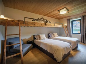 A room with bunk beds, a ladder, a small chair, and a window with curtains. - Ferme V - High-end chalet with spa facilities and gym - OVO Network (Saint-Jean-d'Aulps)