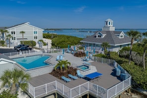 A resort with a pool, lounge chairs, and a view of the ocean. - BG North 81 | Top-Floor Gulf Escape—Golden Sunsets, Endless Skies, Soothing Surf & Pickleball (Boca Grande)