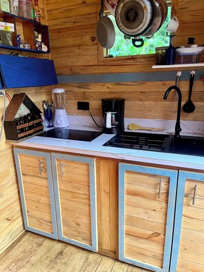 A kitchen with wooden cabinets, a sink, a coffee maker, and various kitchen utensils. - 🏡 Country Owl Cabin, Acto Penthouse for couples, families with children, or friends  (Río verde)