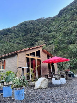 A wooden building with a red roof, surrounded by potted plants and a gravel area. - 🏡 Country Owl Cabin, Acto Penthouse for couples, families with children, or friends  (Río verde)