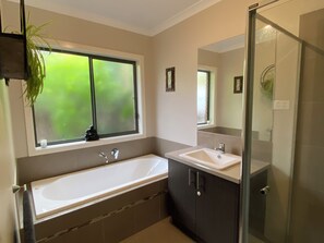 A modern bathroom with a bathtub, a sink, and a glass shower enclosure. - Torquay 3 Bedroom Coastal Retreat (Torquay)