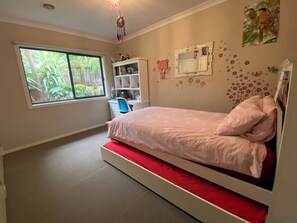 A bedroom with a bed, a desk, a chair, and a window. - Torquay 3 Bedroom Coastal Retreat (Torquay)