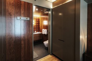 A modern bathroom with a wooden vanity, a toilet, and a towel rack. - Music-Inspired King Suite with Private Kitchen in East Austin (Austin)