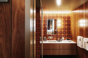 A bathroom with a wooden vanity, a mirror, and a towel rack. - Music-Inspired King Suite with Private Kitchen in East Austin (Austin)