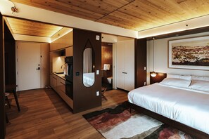 A modern bedroom with a large bed, a wooden ceiling, a built-in wardrobe, and a painting on the wall. - Boutique King Studio with Private Kitchen in East Austin (Austin)