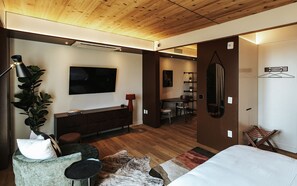 A modern bedroom with a large bed, a desk, a TV, and a dining area. - Boutique King Studio with Private Kitchen in East Austin (Austin)