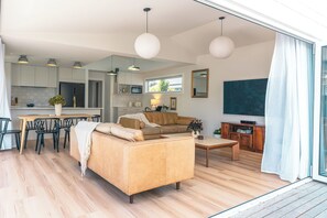 Un salon moderne avec un canapé, une table basse et un coin repas.