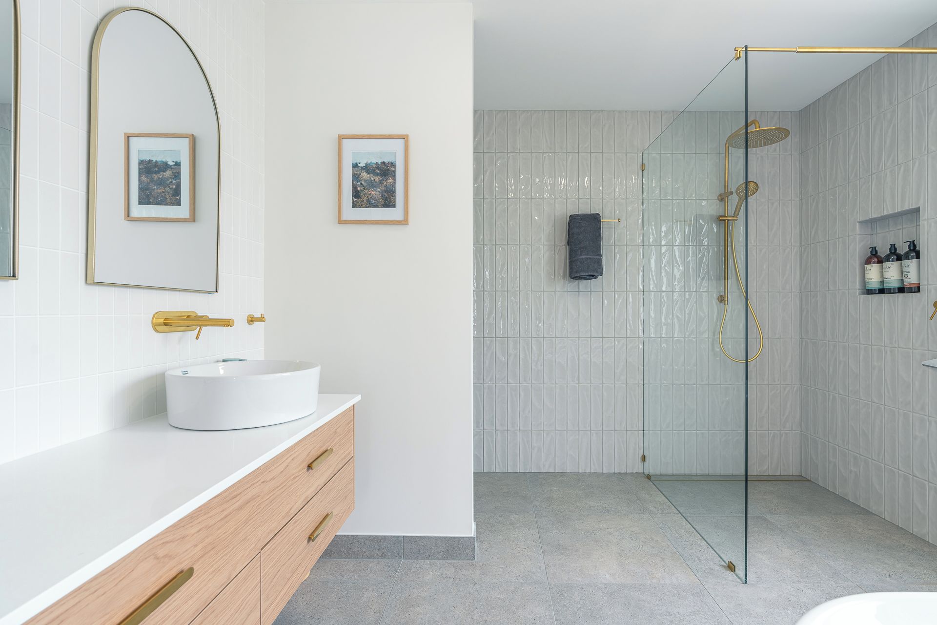 Refresh beneath the generous rainfall shower in the main bathroom, where warm brass finishes and textured tiles bring a polished touch to your daily routine.