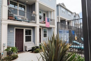 A two-story residential building with a balcony, a front door, and a small porch area. - 3-story Serene Surf Loft in perfect Imperial Beach with AC (Imperial Beach)