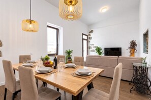 A modern dining area with a wooden table set for four, surrounded by cushioned chairs. - TenoHomes Villa SAYAN, Private Pool & Teide Views (Icod de los Vinos)