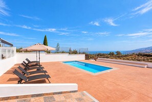 A rooftop pool area with lounge chairs and an umbrella, overlooking a coastal landscape. - TenoHomes Villa SAYAN, Private Pool & Teide Views (Icod de los Vinos)