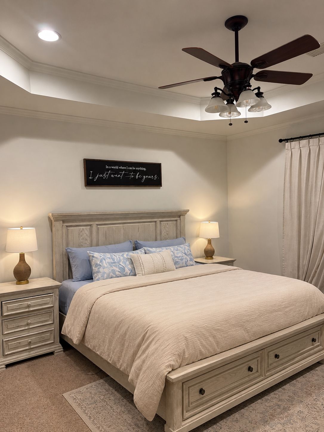 Ein Schlafzimmer mit einem Bett, Nachttischen, einem Deckenventilator und einem an der Wand befestigten Schild.