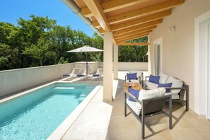 A rooftop pool area with a wooden pergola, lounge chairs, and a table with a bottle and glasses. - Villa Marifran (Istria - Rakalj) (Rakalj)