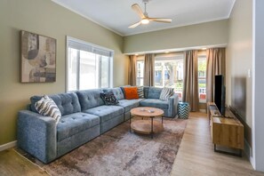 A living room with a sectional sofa, a coffee table, a television, and a ceiling fan. - “Life is Good” | Accessible Stay Near the Falls (Niagara Falls)