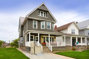 A two-story house with a front porch, a garage, and a well-maintained lawn. - “Life is Good” | Accessible Stay Near the Falls (Niagara Falls)
