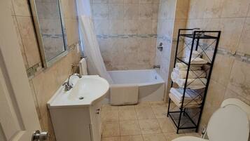 A bathroom with a sink, toilet, shower, and a towel rack.