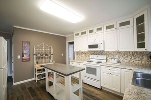 A kitchen with white cabinets, a microwave, an oven, and a granite countertop. - Perfect for Large Groups 10BR Sleeps 26 Near Falls (Niagara Falls)