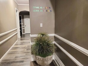 A hallway with a potted plant, a wall with a welcoming message, and a door labeled 'Closet'. - Perfect for Large Groups 10BR Sleeps 26 Near Falls (Niagara Falls)