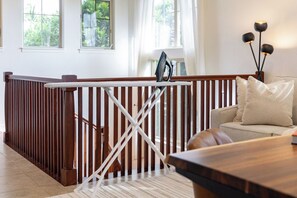 Ein Zimmer mit Hollafassung, einem weißen Bügelbrett, einem Sofa und einer Lampe.