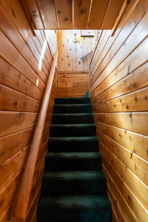 A wooden staircase with carpeted steps leading upwards. - Sierra Chalet - Celebrity Vacation Homes (Big Bear Lake)