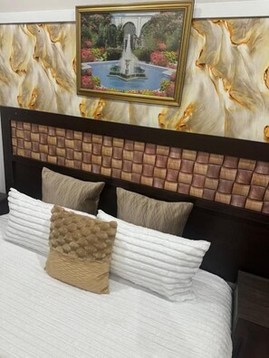 A bed with a headboard featuring a brick pattern, a framed picture above the bed, and a textured pillow. - Comrades villa guest house  (Pietermaritzburg)