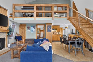 A spacious loft-style living area with a high ceiling, a dining area, and a kitchen. - Private Mountainside Retreat | Near Wineries & Bristol Mountain (Naples)
