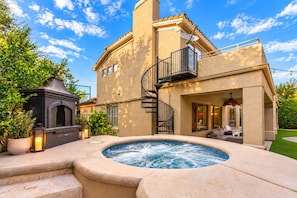 A two-story house with a hot tub, outdoor seating, and a fireplace. - NEW|Lionsgate Luxe Estate | Pool + Spa | Golf Sim (Gilbert)