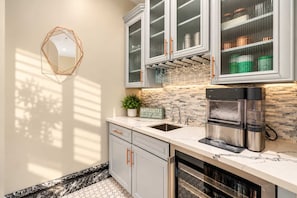 A modern kitchen with a built-in oven, a sink, and upper cabinets with glass doors. - NEW|Lionsgate Luxe Estate | Pool + Spa | Golf Sim (Gilbert)