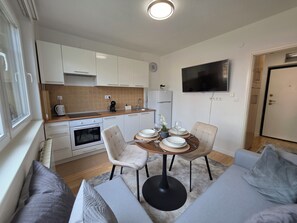 Un espacio habitable funcional con kitchenette, comedor y zona de estar.