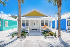 A motel with a central entrance, numbered rooms, and a no parking sign. - Lemon Tree Cottage at White Sands | updated 2br/1ba steps to beach (Indian Rocks Beach)