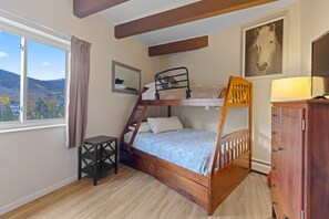 A bunk bed room with a window, a desk, and a dresser. - Lake Dillon and Mountain Views! (Dillon)