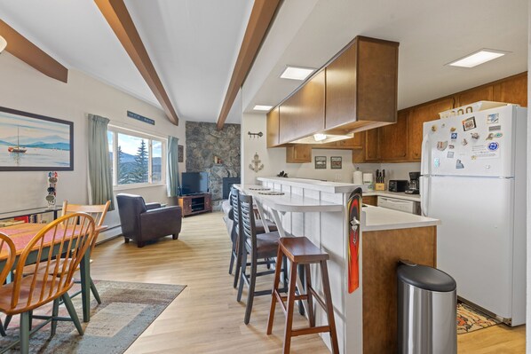 Eine moderne Küche mit Holzausbau, einer weißen Arbeitsplatte und einem Edelstahlkühlschrank.