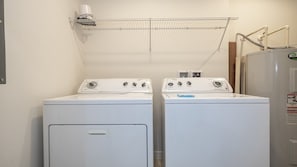 A laundry area with two front-loading washing machines and a dryer. - Near Disney at Encantada Resort Cozy Townhouse (Kissimmee)