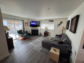 A living room with a fireplace, a television, and a sofa. - Kirkland - Rose Hill Duplex Top Floor Luxurious Oasis + EV (Kirkland)