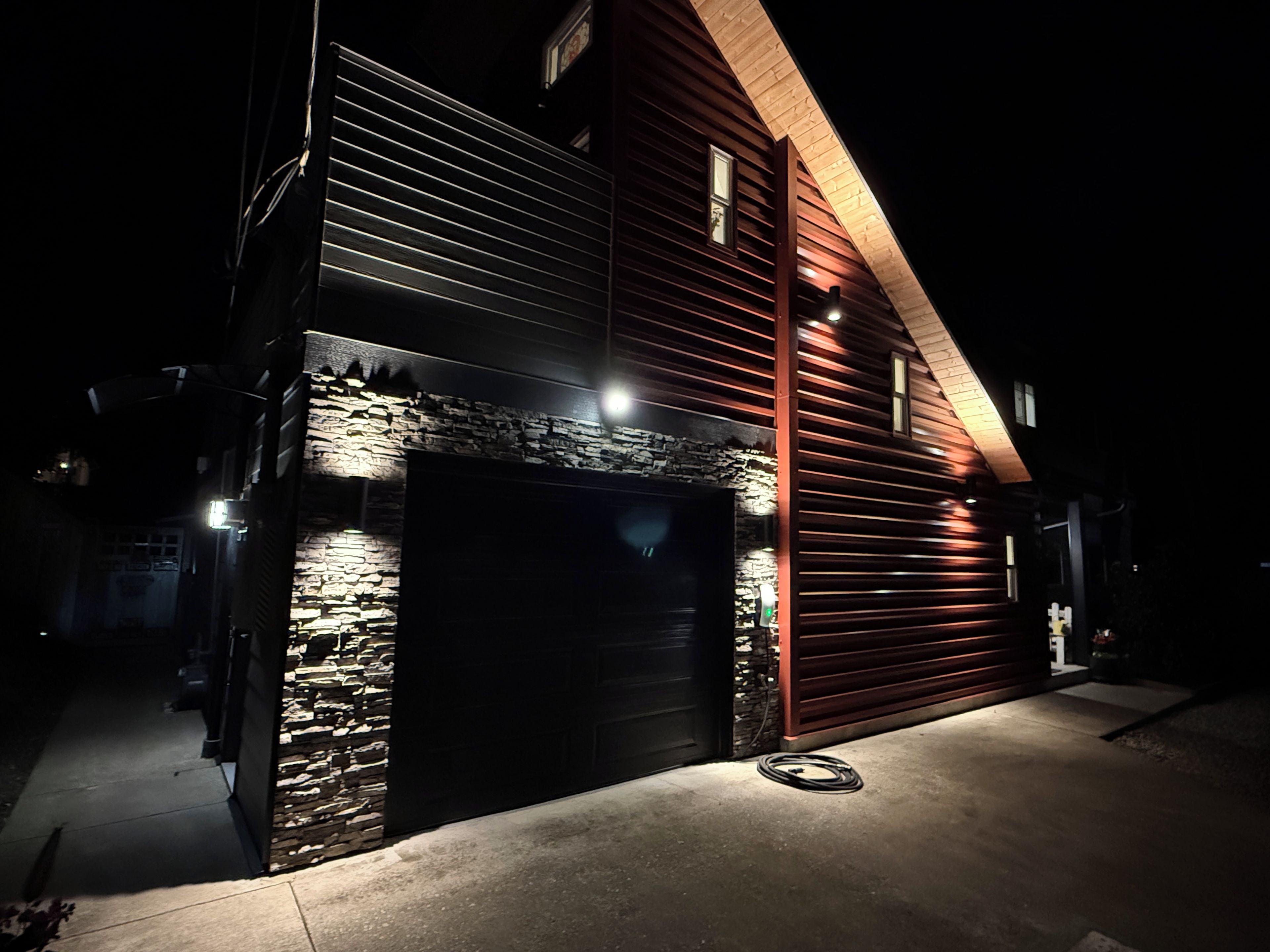 A two-story building with a stone facade and a dark garage door.