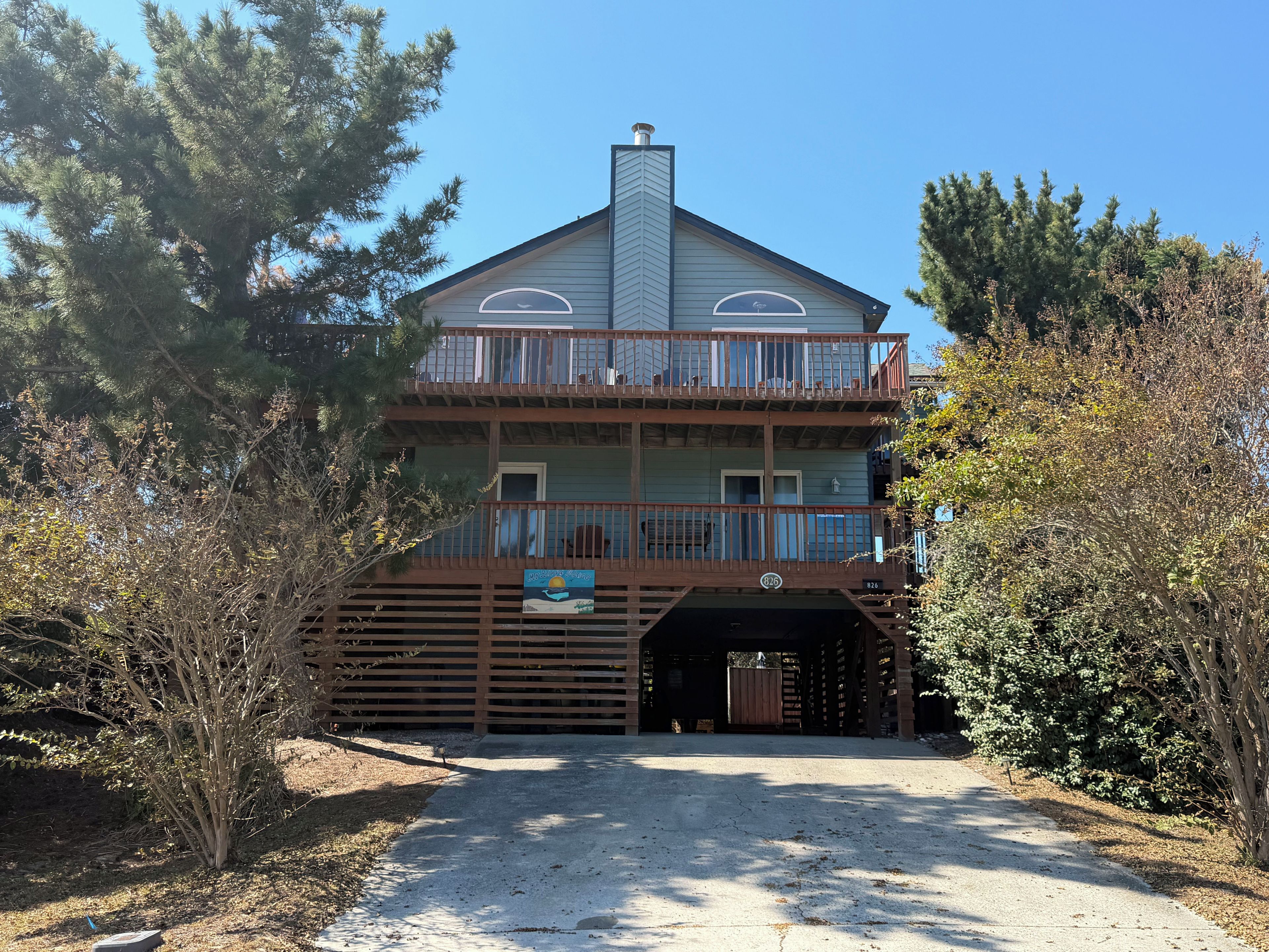 A two-story building with a balcony on the upper floor, a covered entrance, and a sign indicating a marina.