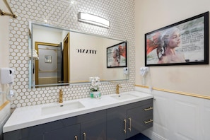 A bathroom with a double sink, gold faucets, a mirror with a gold frame, and a framed quote on the wall. - Serene 20 Bedroom Oasis in Davenport City 6690 (Orlando)