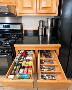 Een keuken met een lade-organizer vol kruiden en keukengerei.