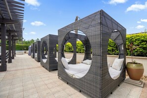 Outdoor wicker seating areas with circular arches, a tiled walkway, and a large potted plant. - Modern 4 Bedroom Townhome in Downtown Orlando, 6687 (Orlando)