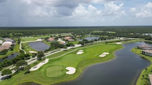 An aerial view of a golf course with multiple water hazards, sand bunkers, and residential buildings. - Cozy 3 Bedroom House in Punta Gorda, 5921 (Charlotte County)
