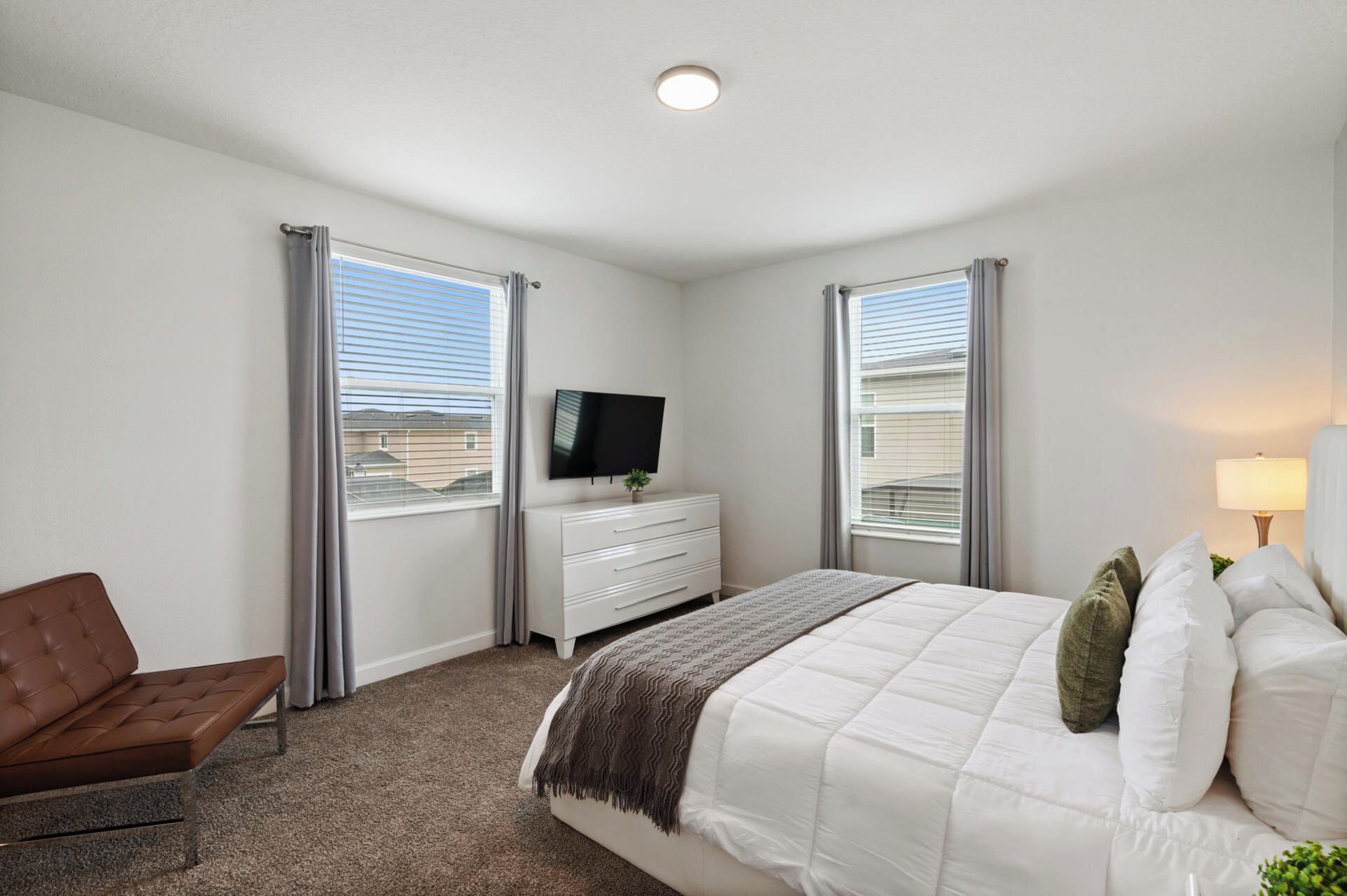 Une chambre à coucher avec un lit, une télévision, une chaise et une commode.