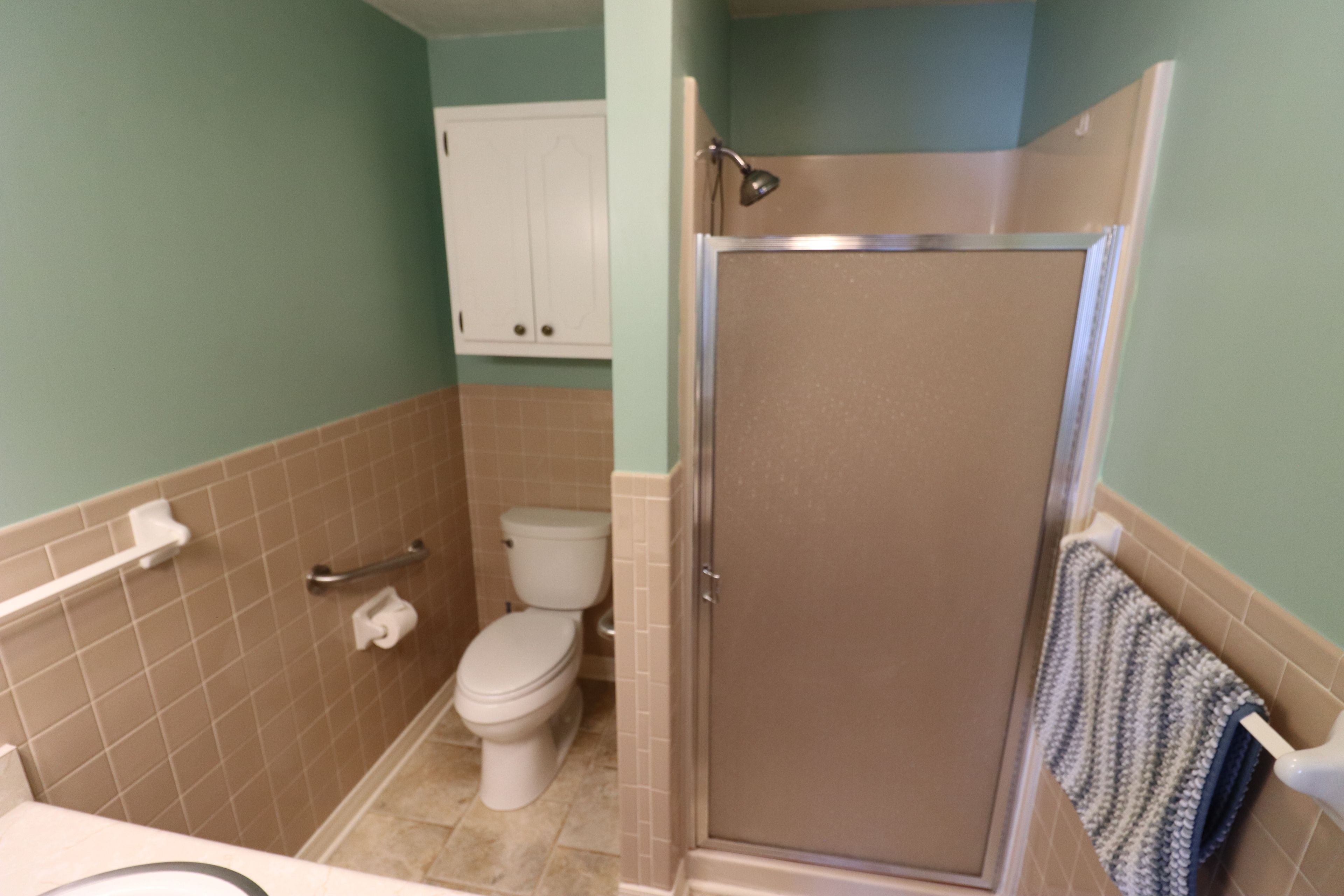 Un bagno con il WC, uno spazio doccia e un porta asciugamani.