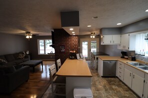 A modern kitchen with a central island, built-in appliances, and a dining area with a sofa and chairs. - Beautiful Lake Front 3-bedroom house with AC in soothing Horseshoe Bend Arkansas (Horseshoe Bend)