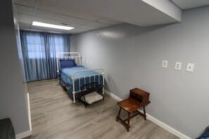 A bedroom with a single bed, a wooden chair, and a window with curtains. - Beautiful Lake Front 3-bedroom house with AC in soothing Horseshoe Bend Arkansas (Horseshoe Bend)