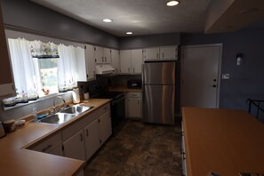 A modern kitchen with stainless steel appliances, a built-in oven, and a dishwasher. - Beautiful Lake Front 3-bedroom house with AC in soothing Horseshoe Bend Arkansas (Horseshoe Bend)