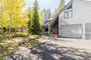A residential property with a garage, a covered porch, and a driveway leading to the house. - Sunriver Fun - Fireplaces, Hot tub & SHARC (Sunriver)