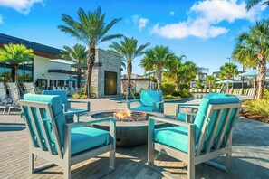An outdoor seating area with lounge chairs and a fire pit. - Elegant Estate Living in Orlando's Heart, 6697 (Orlando)