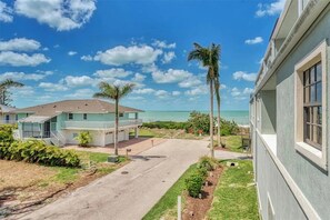 Une propriété située en bord de mer, comprenant une maison à deux étages, une véranda et une vue sur l’océan.